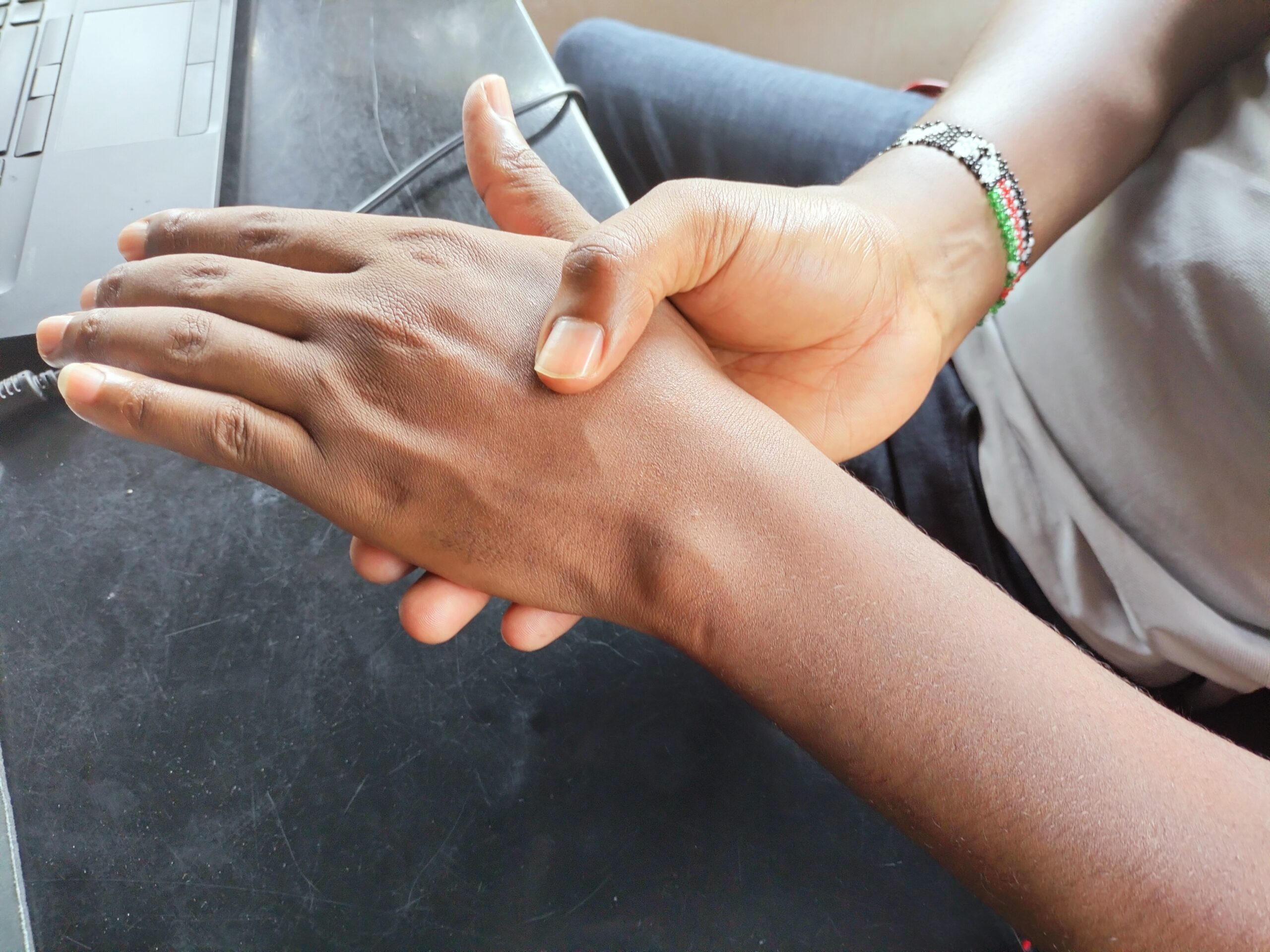 A physical therapist assisting a patient with hand and wrist exercises.